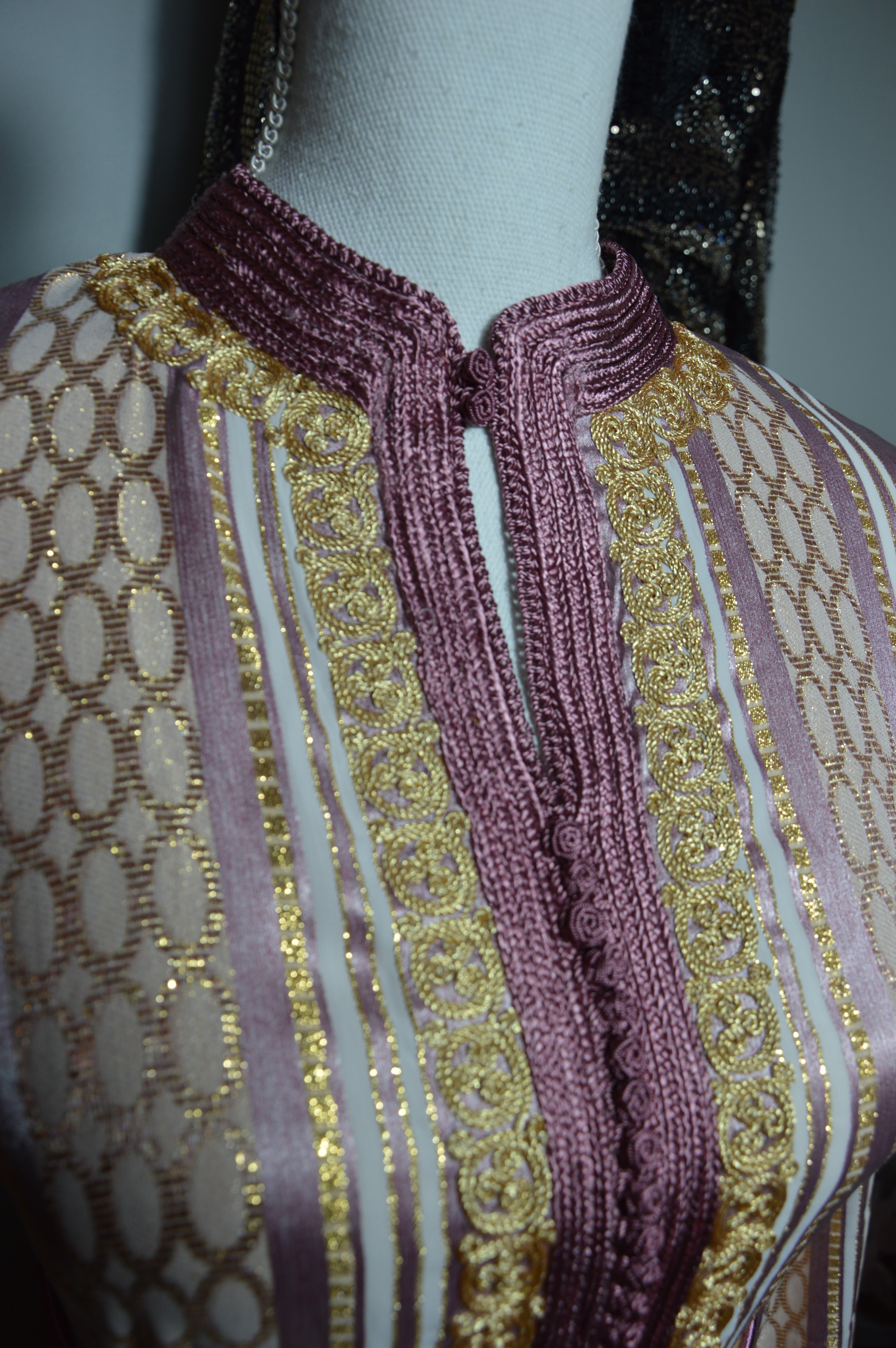 Détail broderies dorées artisanales sur caftan rose prune