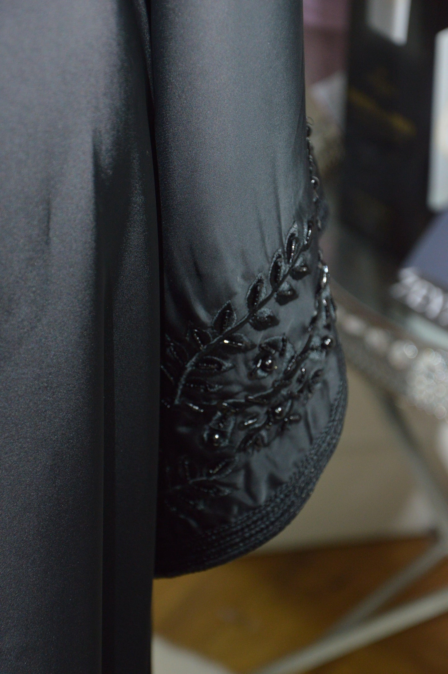 Caftan noir brillant luxe - détail broderie manche évasée - robe marocaine élégante