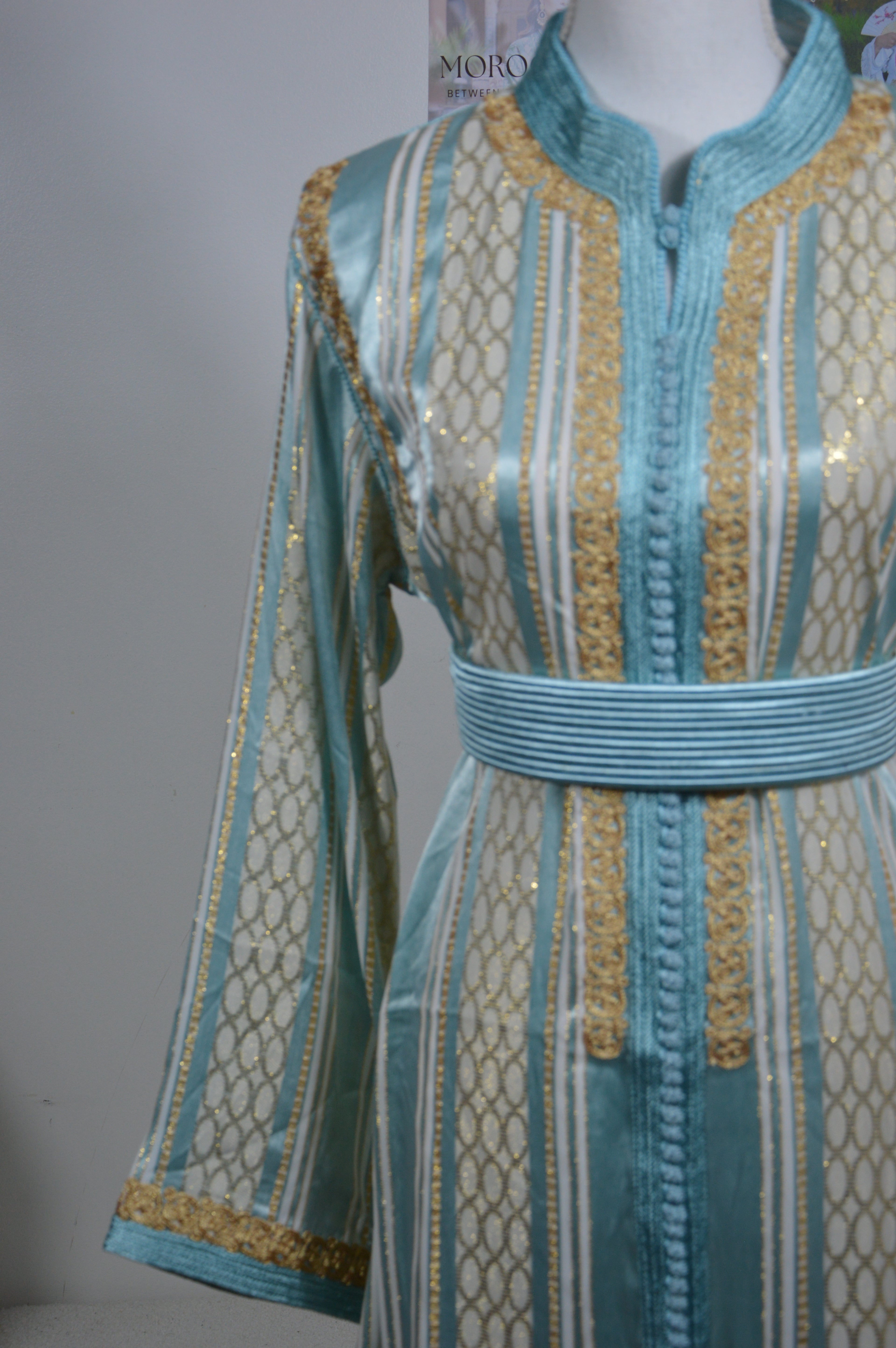 Détail broderies dorées artisanales sur caftan bleu turquoise